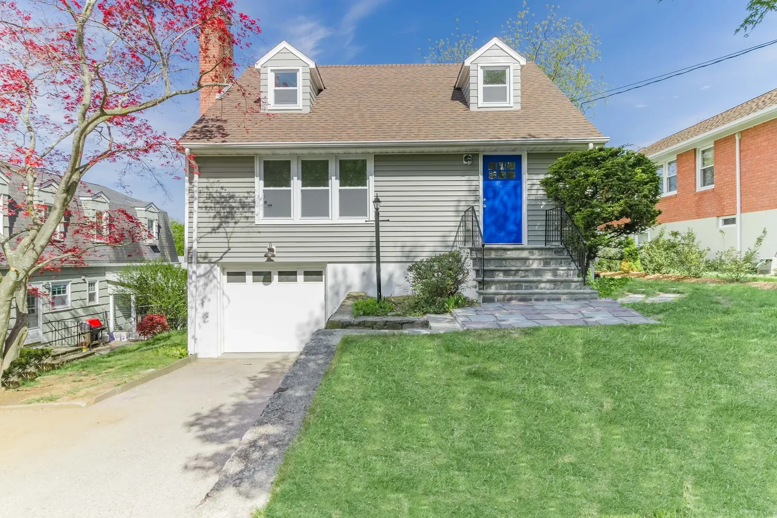 Cape with gray siding and a blue front door
