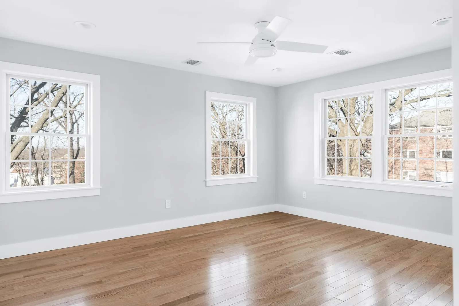 Bedroom with corner windows and hardwood floors