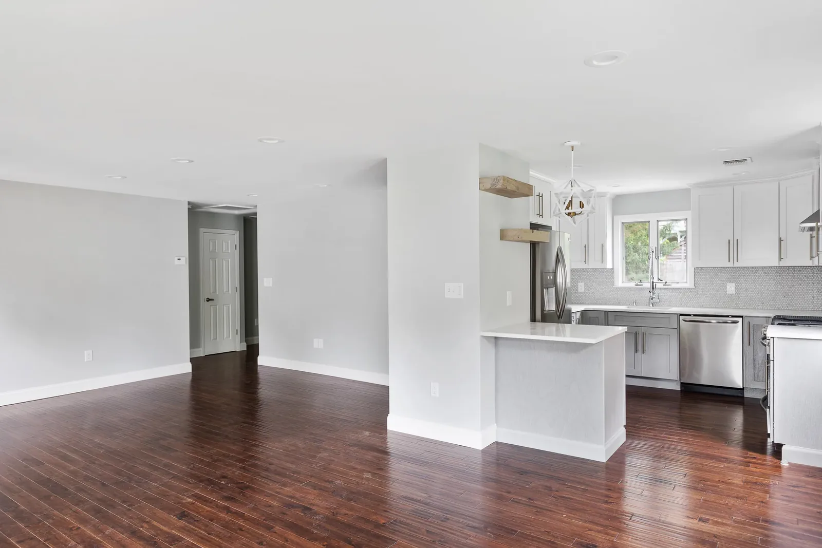 Open kitchen and living area with dark floors