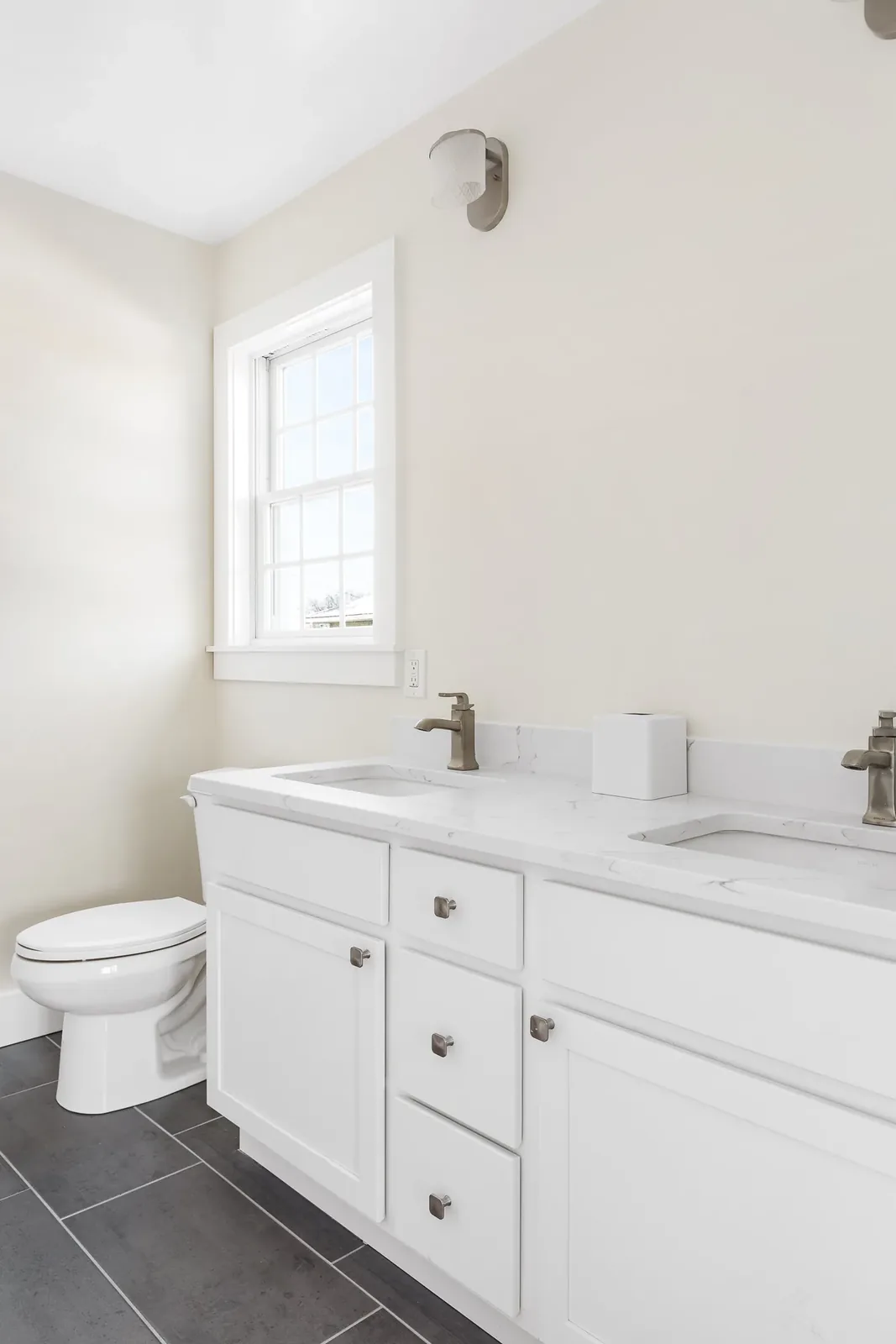 Bathroom with double vanity and gray tile floor