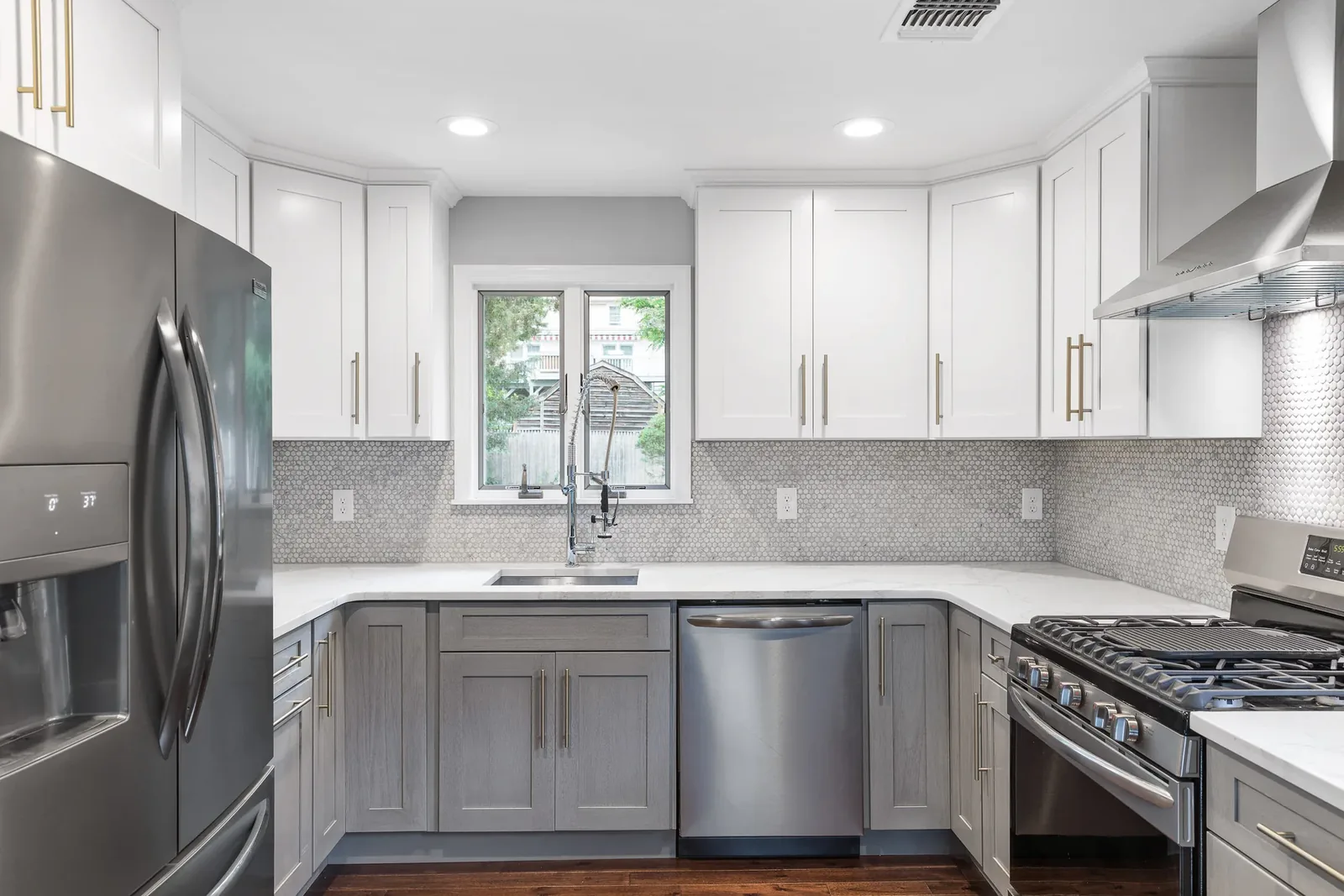 White and gray kitchen with marble island and geometric pendant