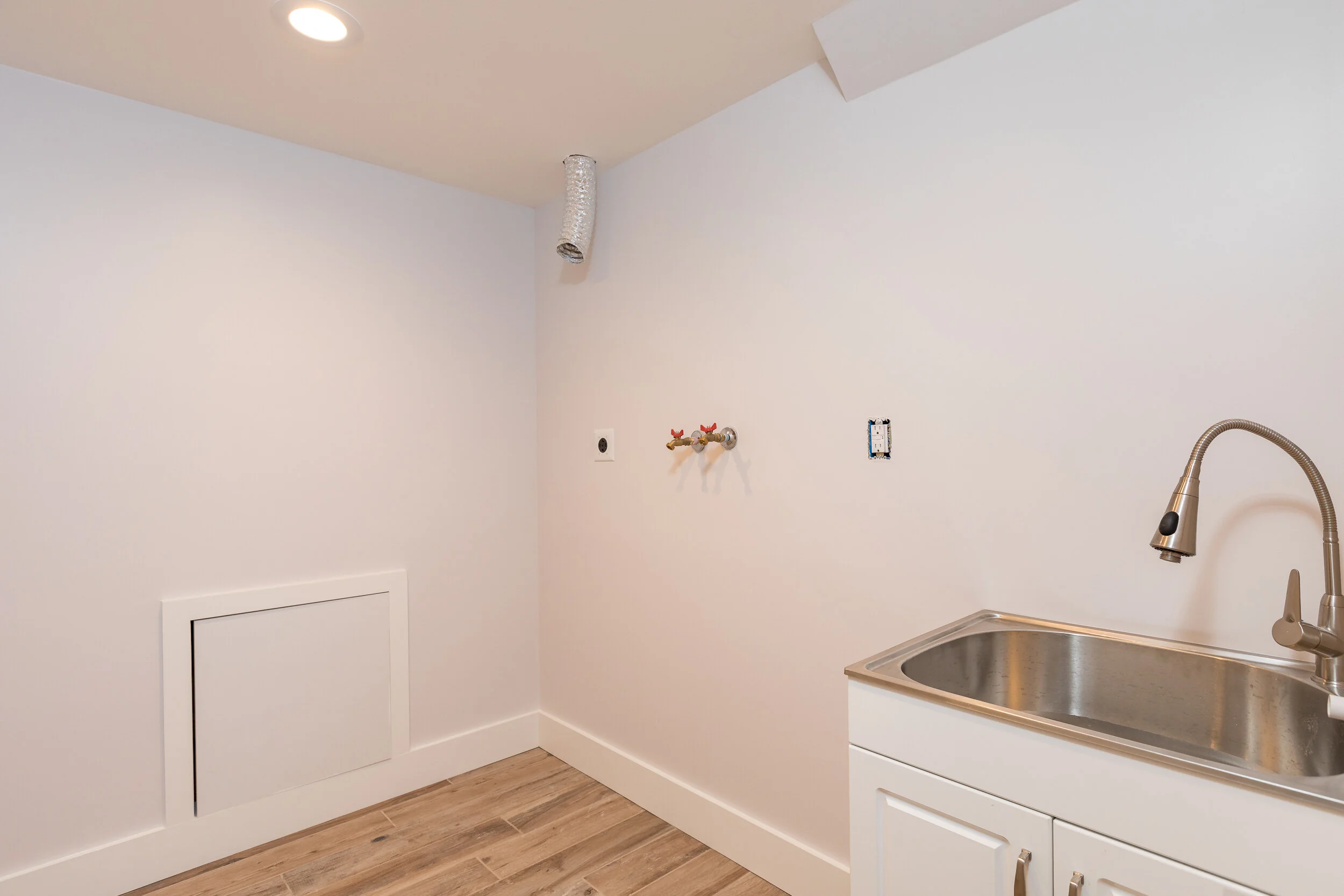 Kitchen area with a stainless sink and a wall-mounted pot filler