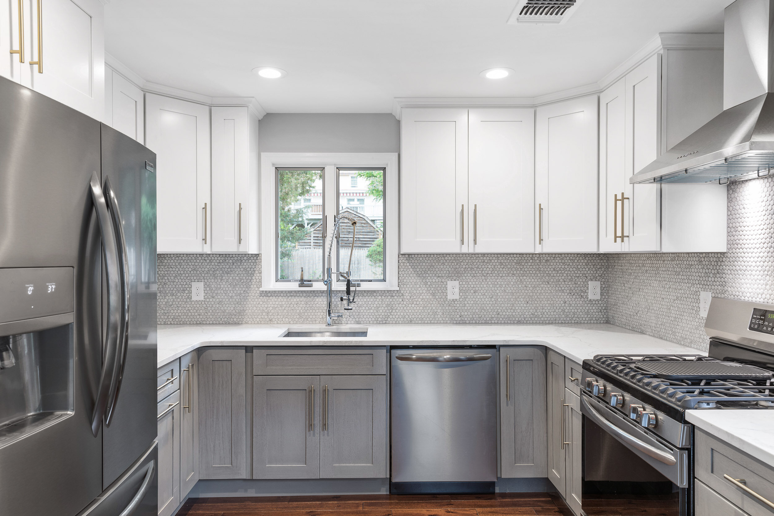 Renovated gray and white kitchen with brass hardware