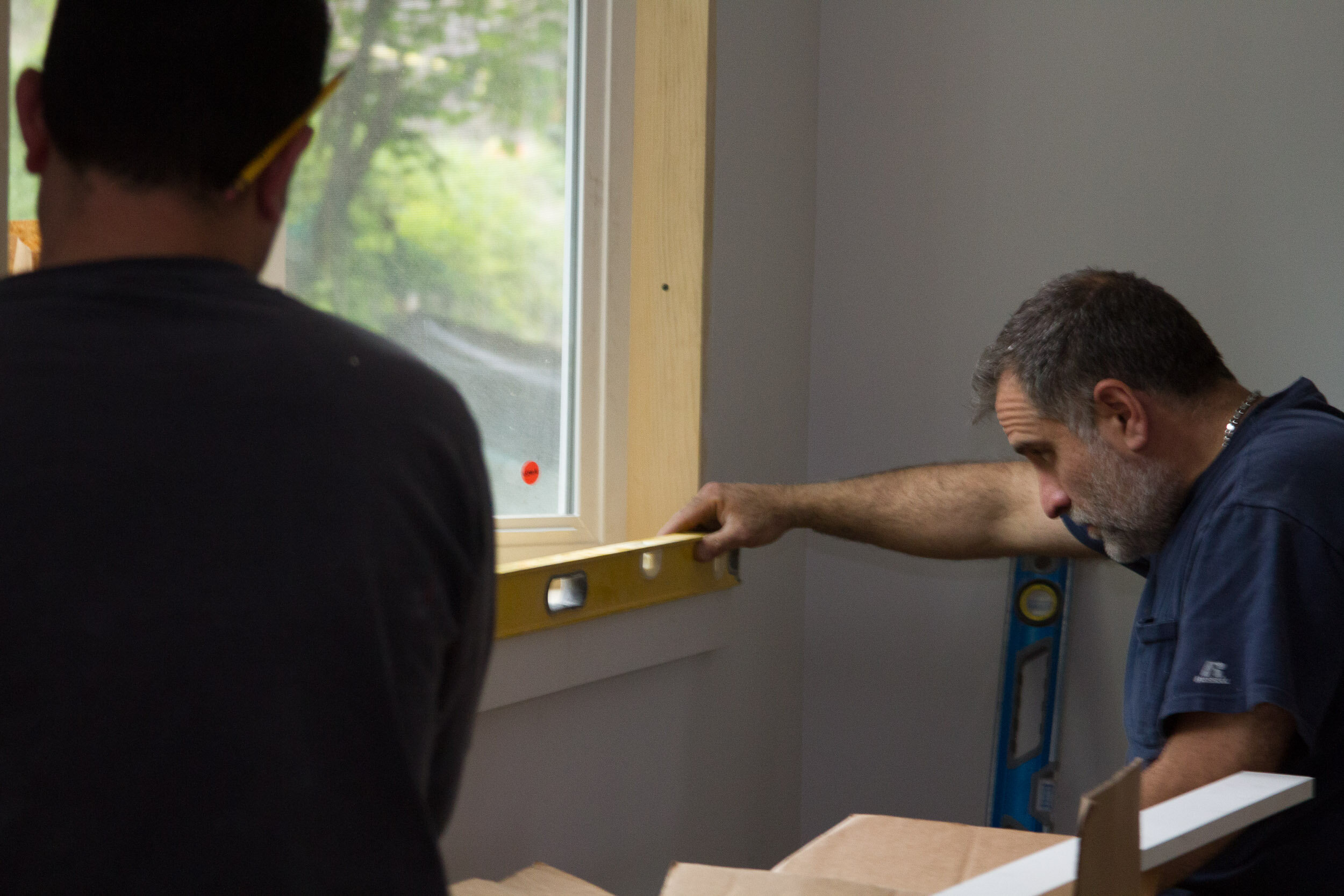 Pat checking a window sill with a level