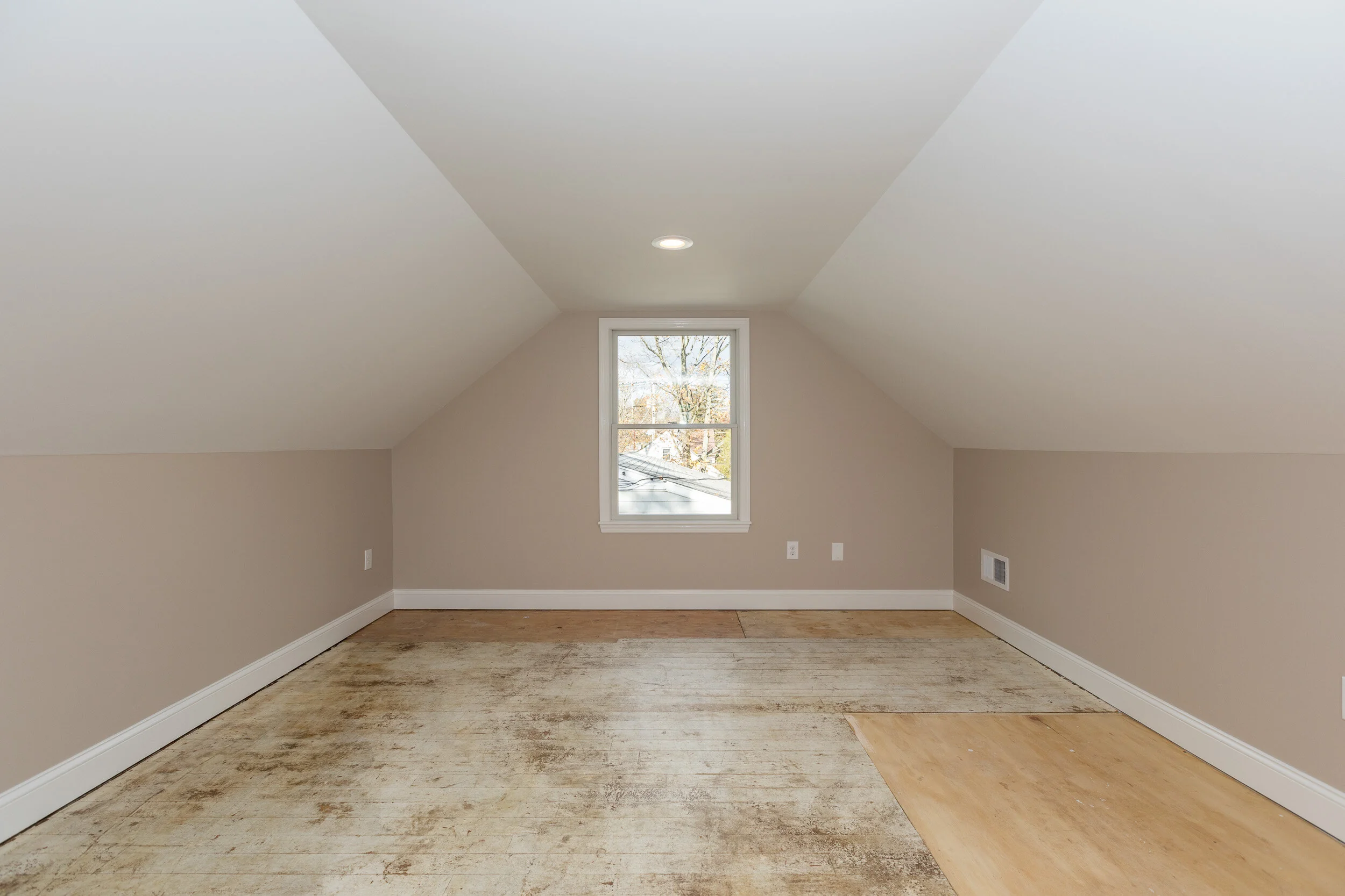 Finished upper-level room with a vaulted ceiling and a dormer window
