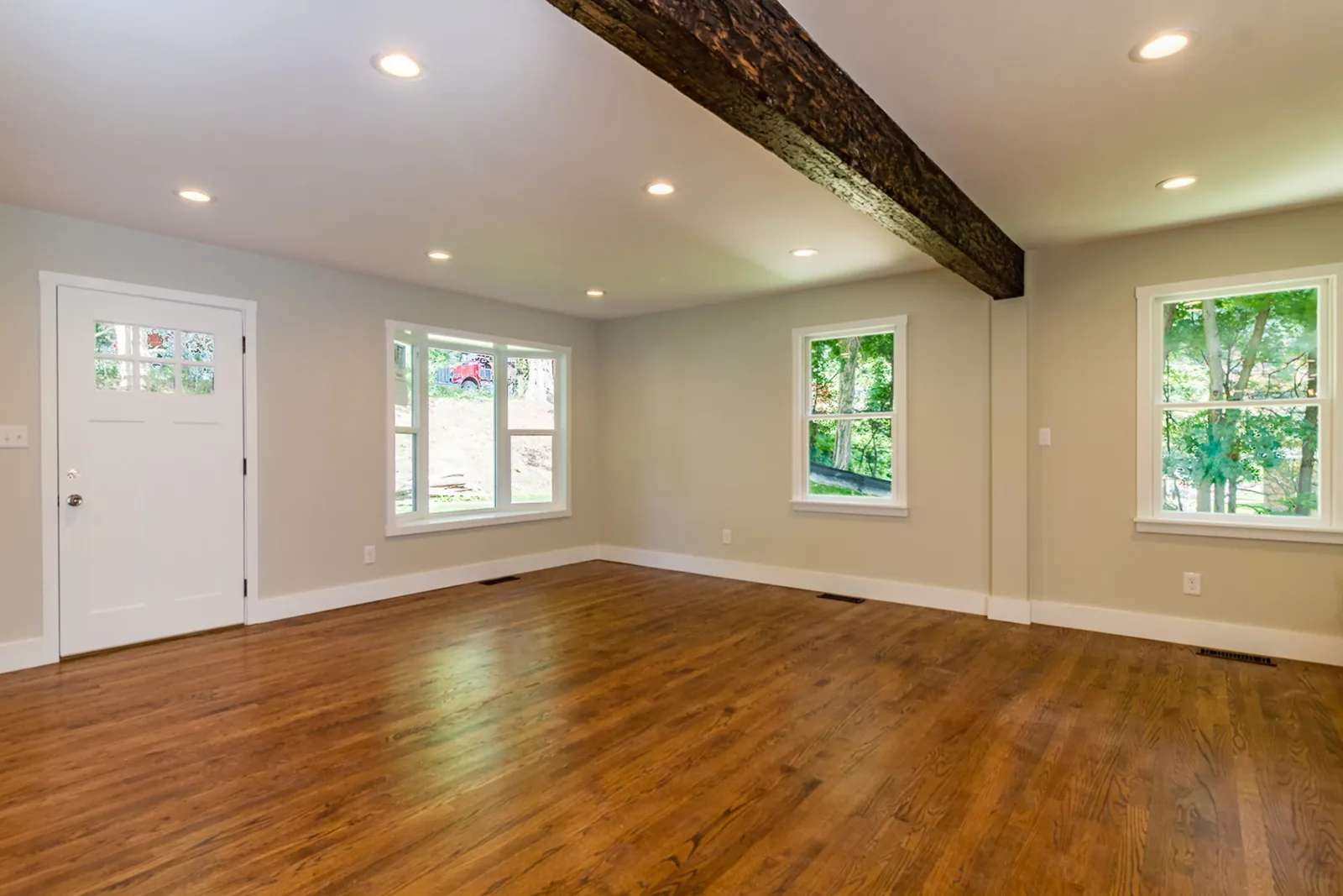 Living space with an exposed ceiling beam and hardwood floors
