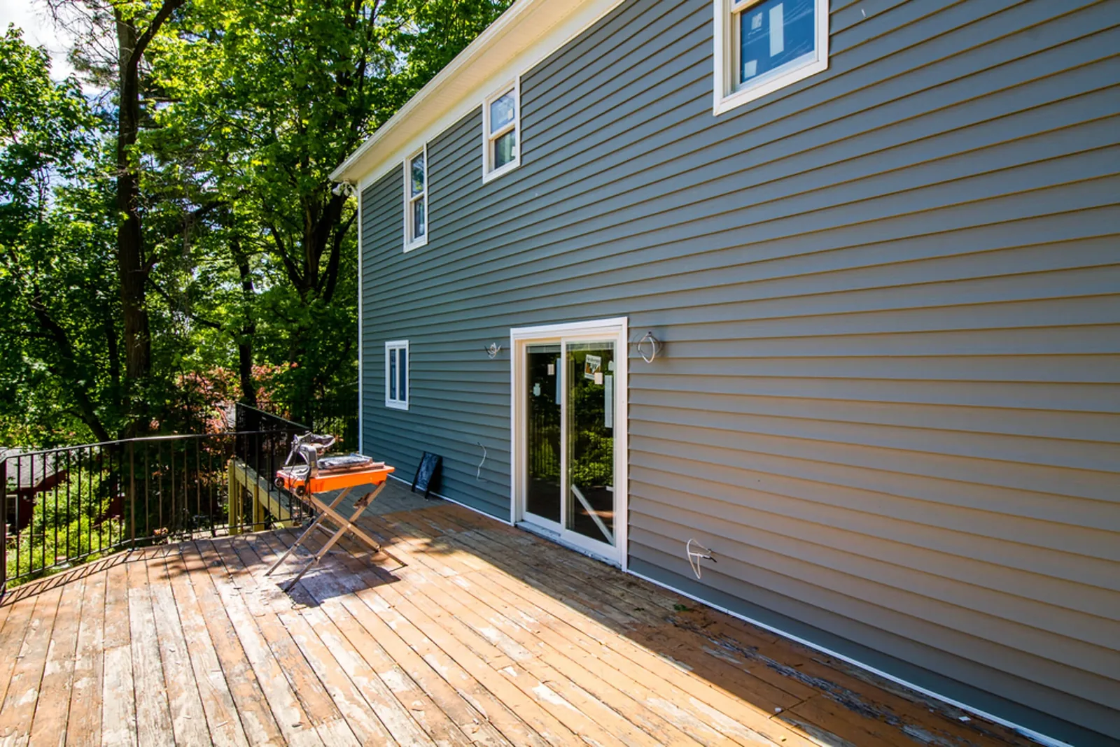 Side exterior with gray lap siding and an elevated deck