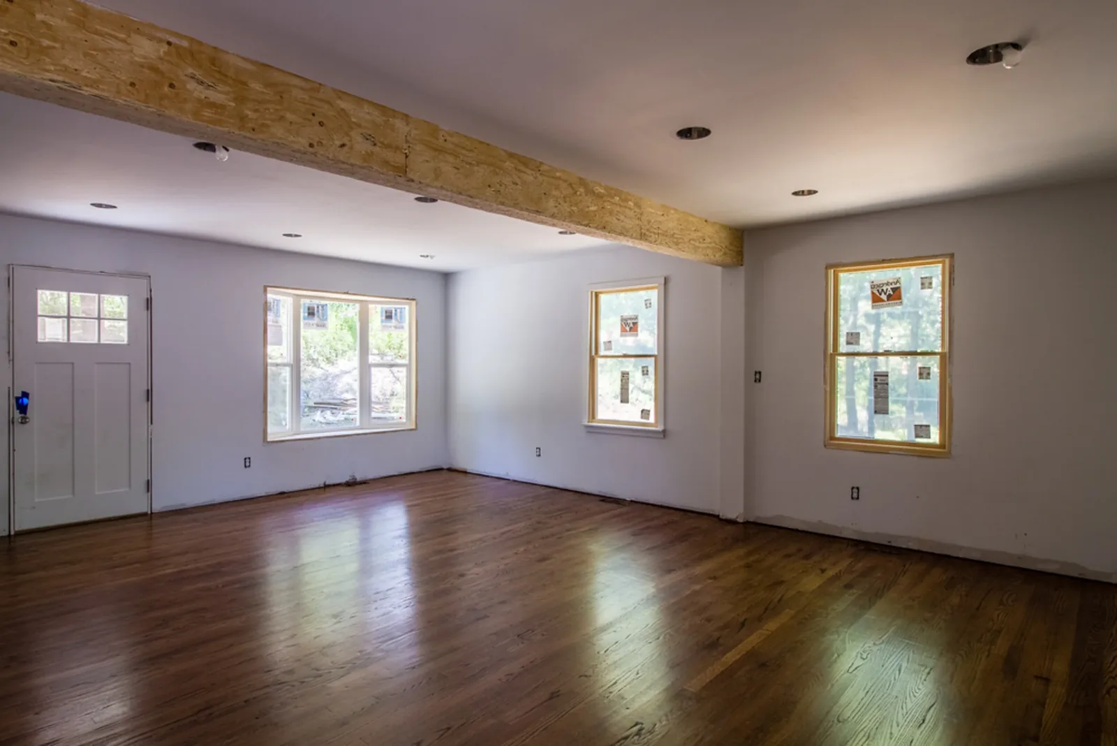 Open main floor with hardwood floors and a wall of windows