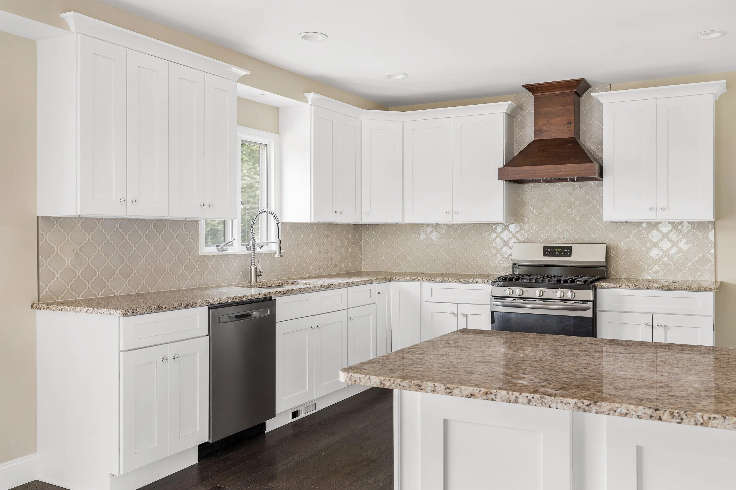 Custom kitchen with island and wood range hood at 17 Michaels Lane