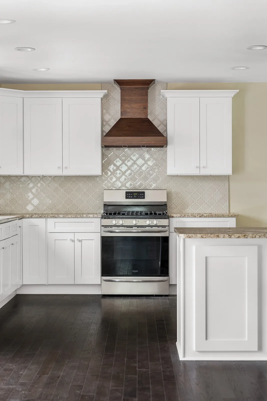 Wood range hood over the stove with arabesque tile