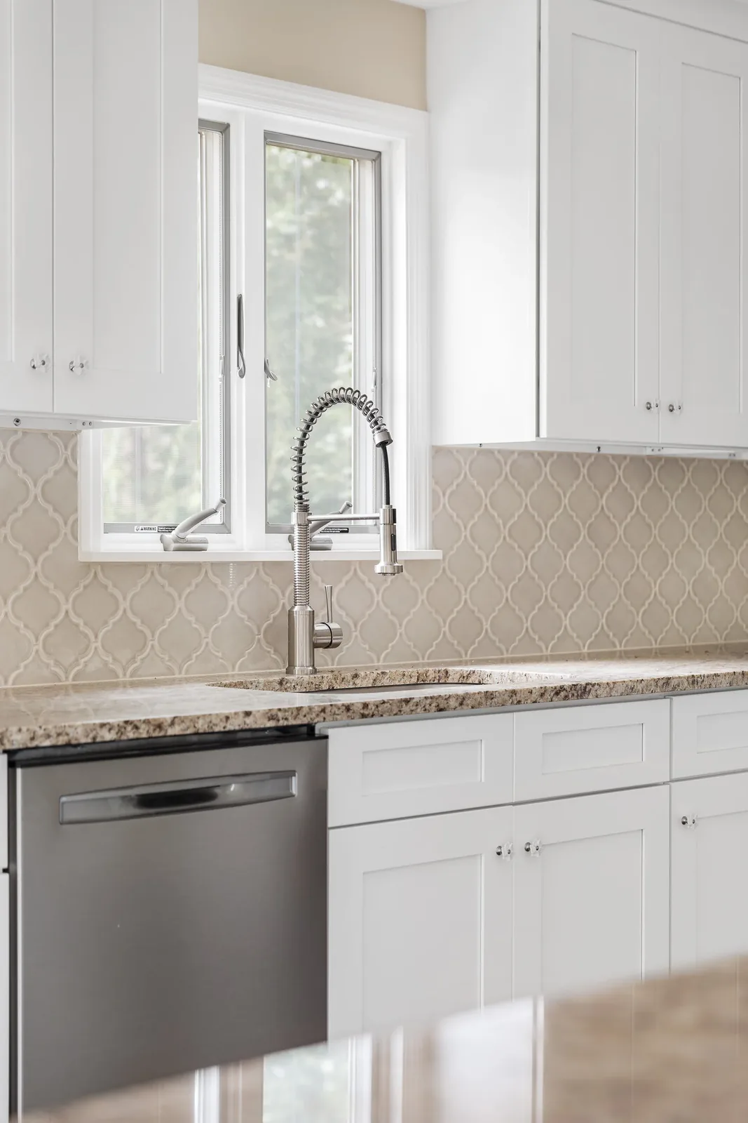Faucet and arabesque tile backsplash at the kitchen sink