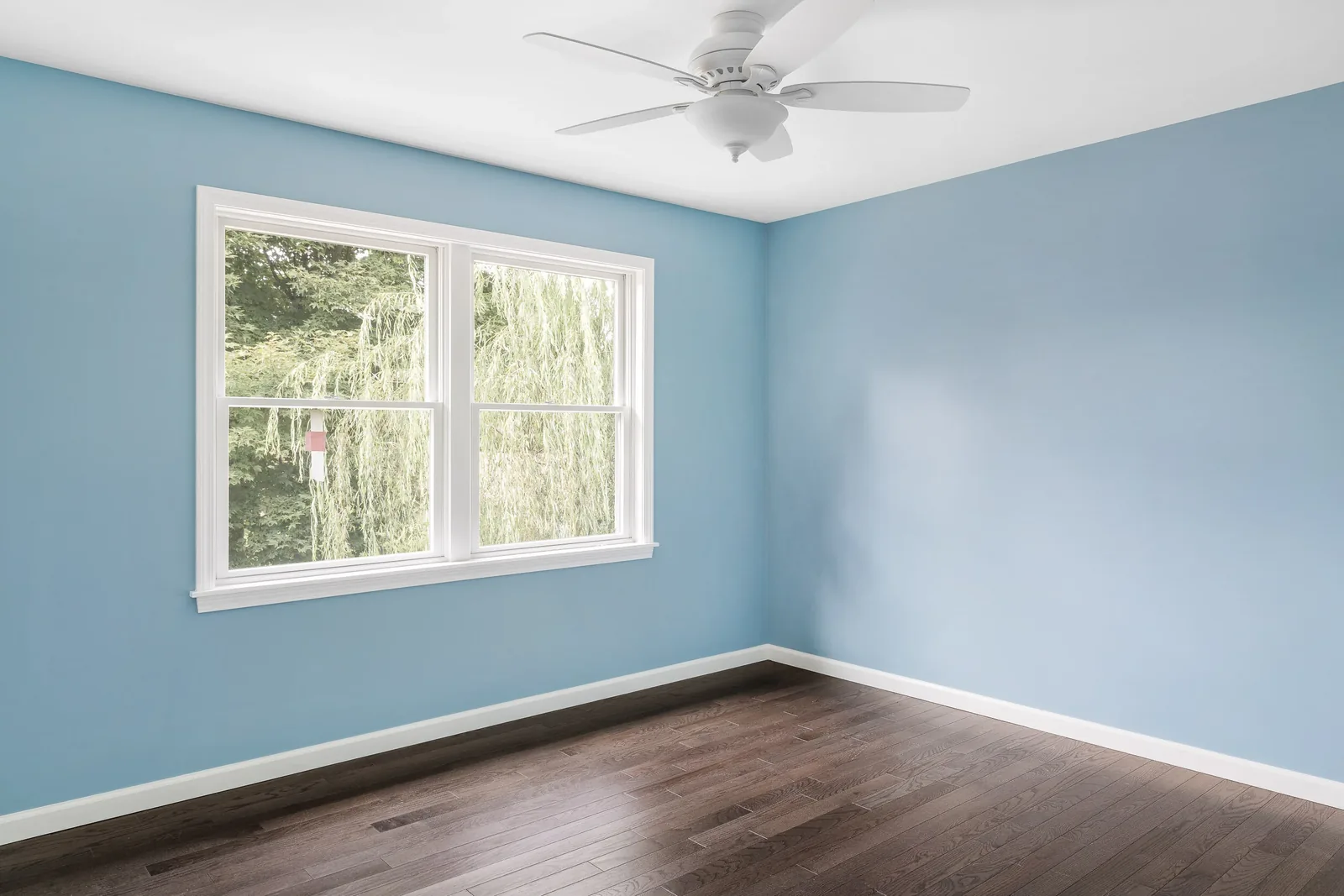 Blue bedroom with ceiling fan and new windows