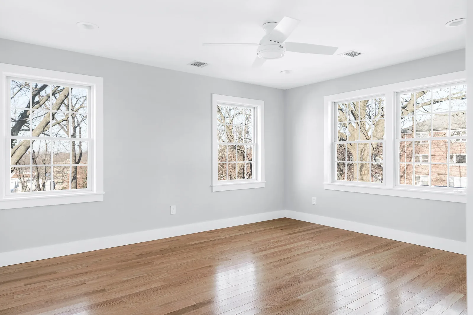 Bright living room with soft gray walls and refinished hardwood floors