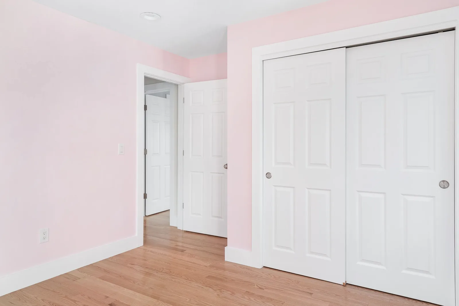 Room with pink walls and a white closet