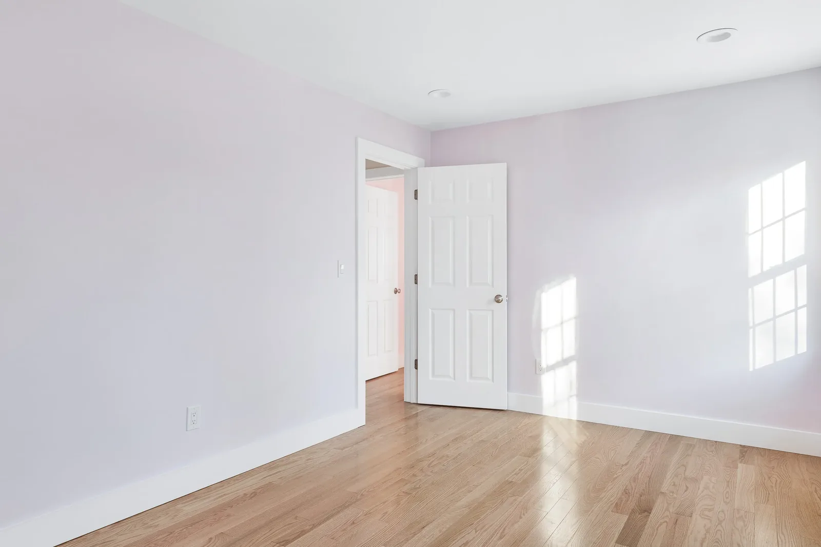 Room with soft lilac walls and hardwood floors