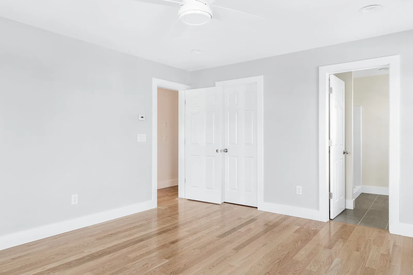 Neutral room with hardwood floors and bright windows