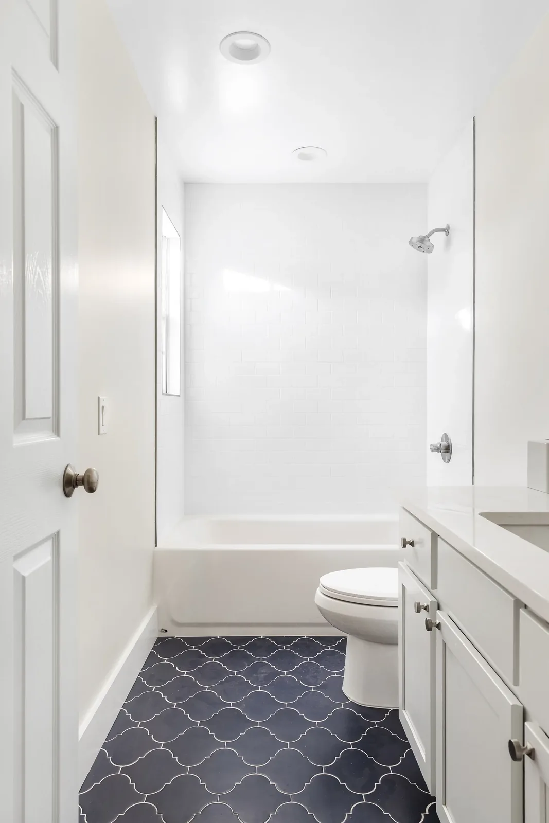 Refreshed bath with a white tiled tub surround