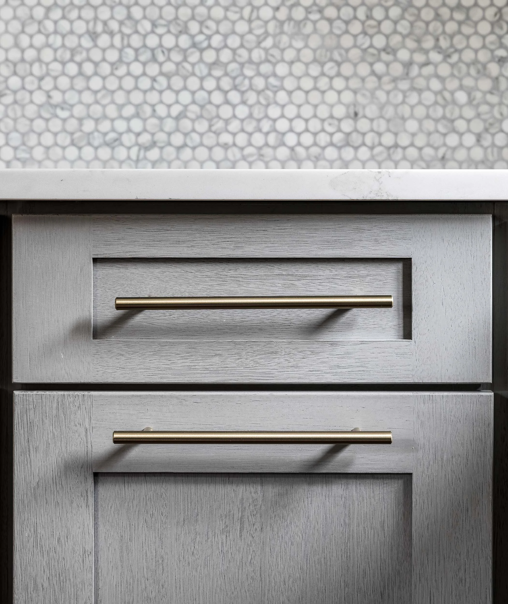 Gray cabinet drawers with brass bar pulls