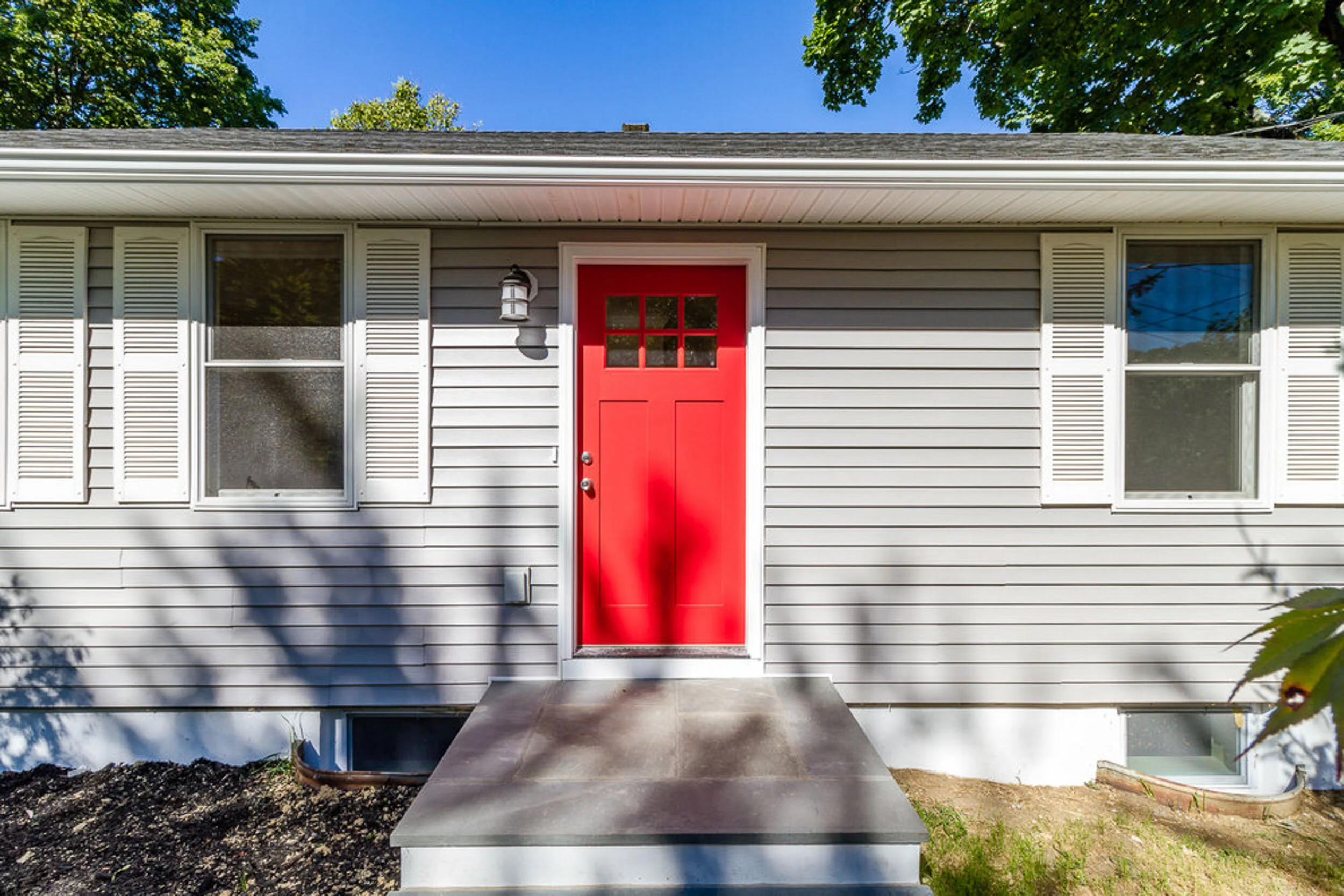 New red craftsman front door with gray siding