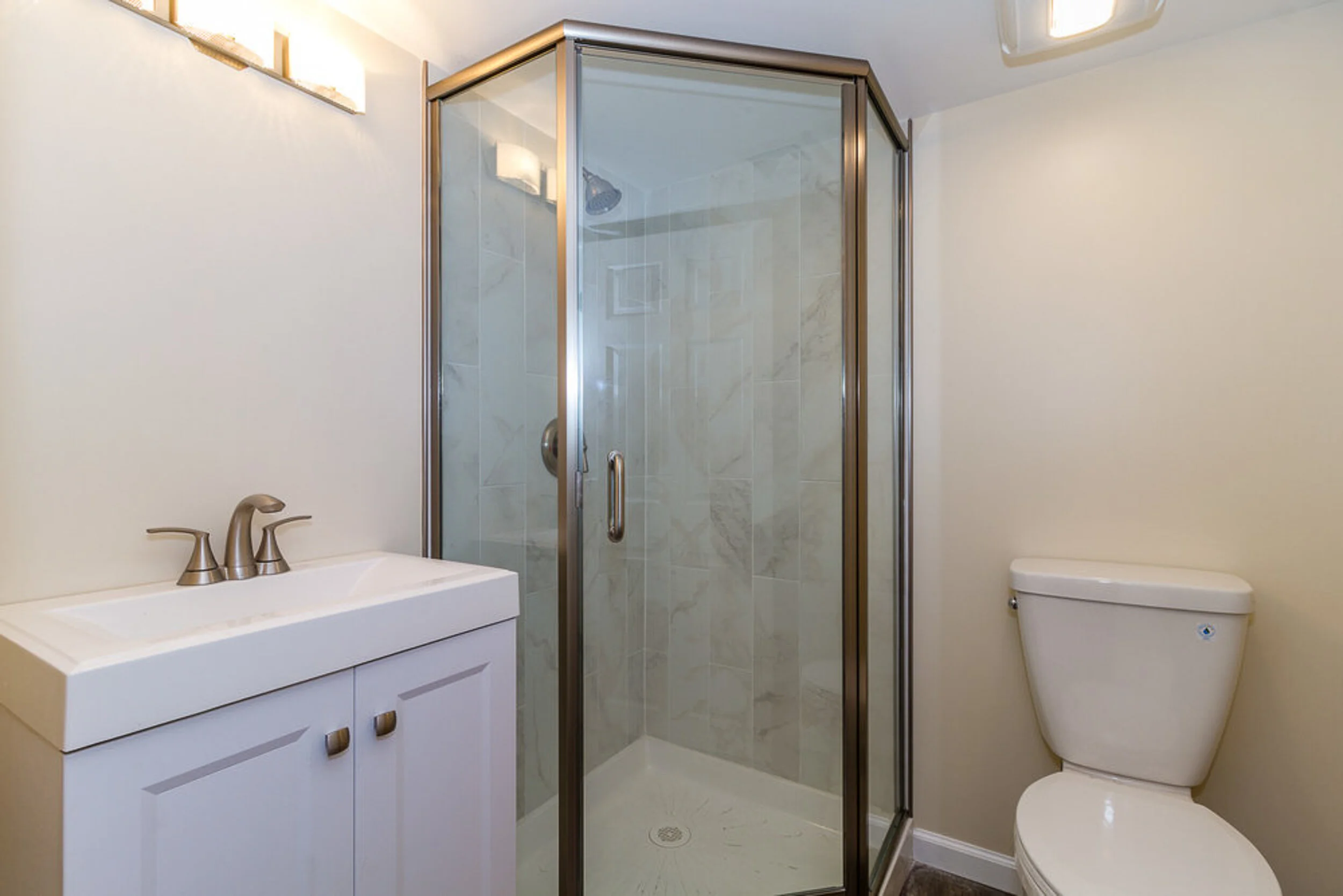 Basement bathroom with corner shower and vanity