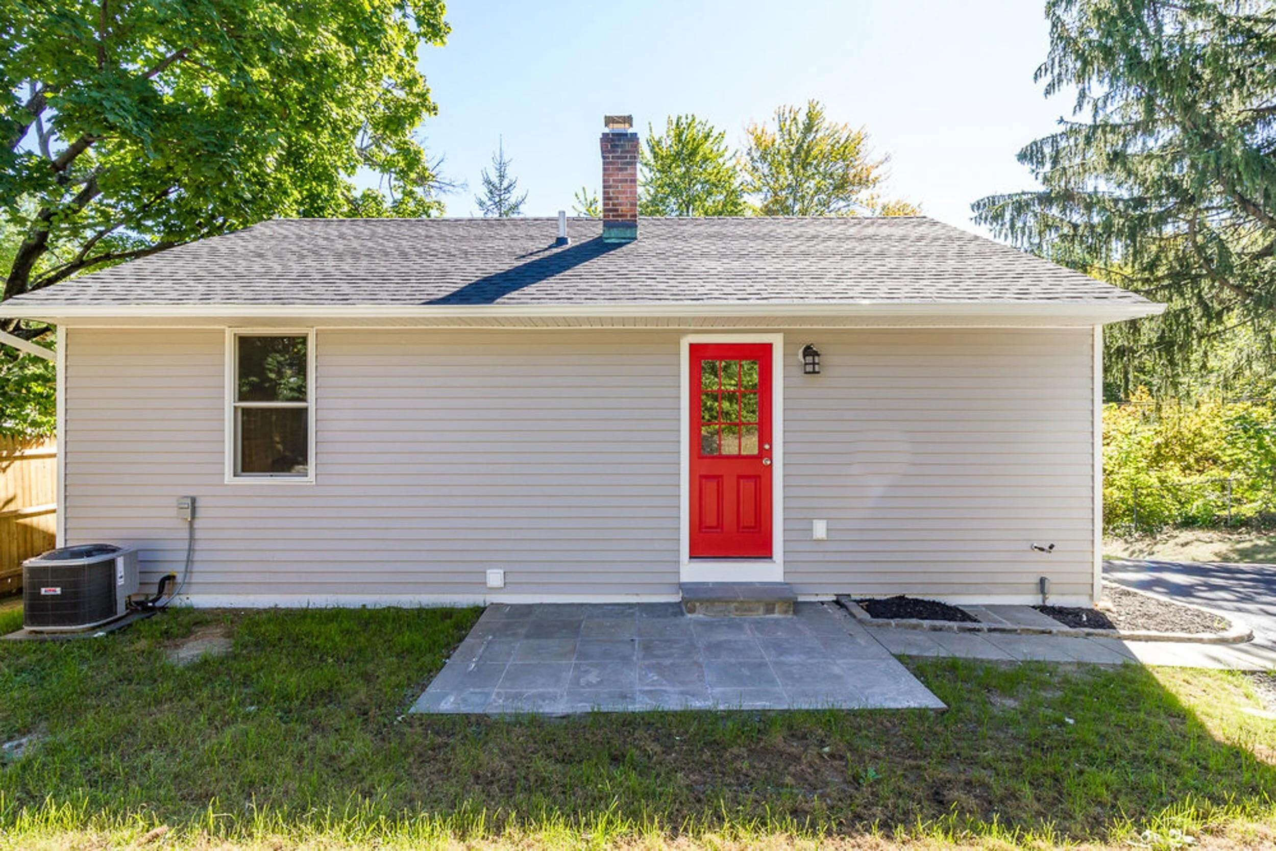 Rear exterior with red door and bluestone patio