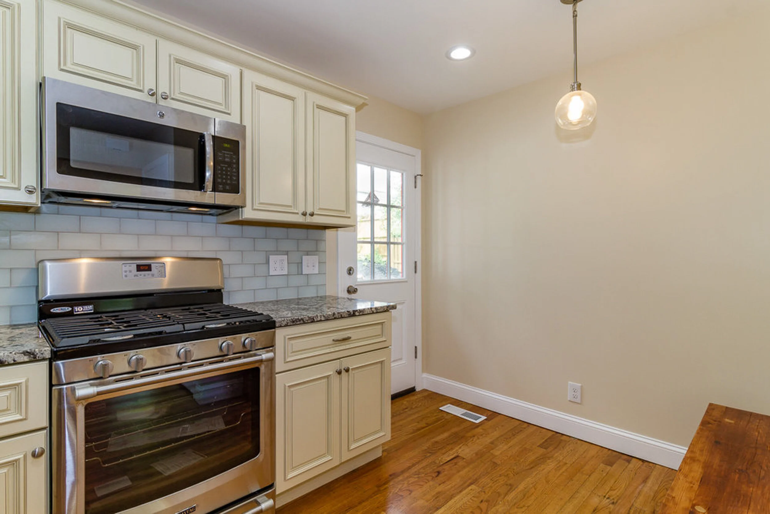 Gas range and microwave against the subway tile backsplash