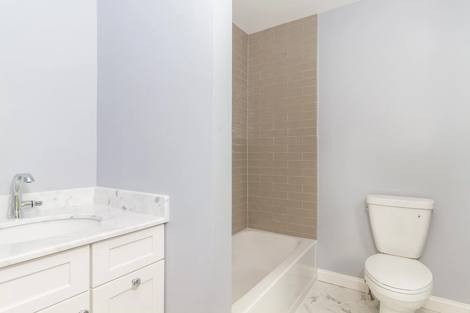 Bathroom with tub and taupe subway tile