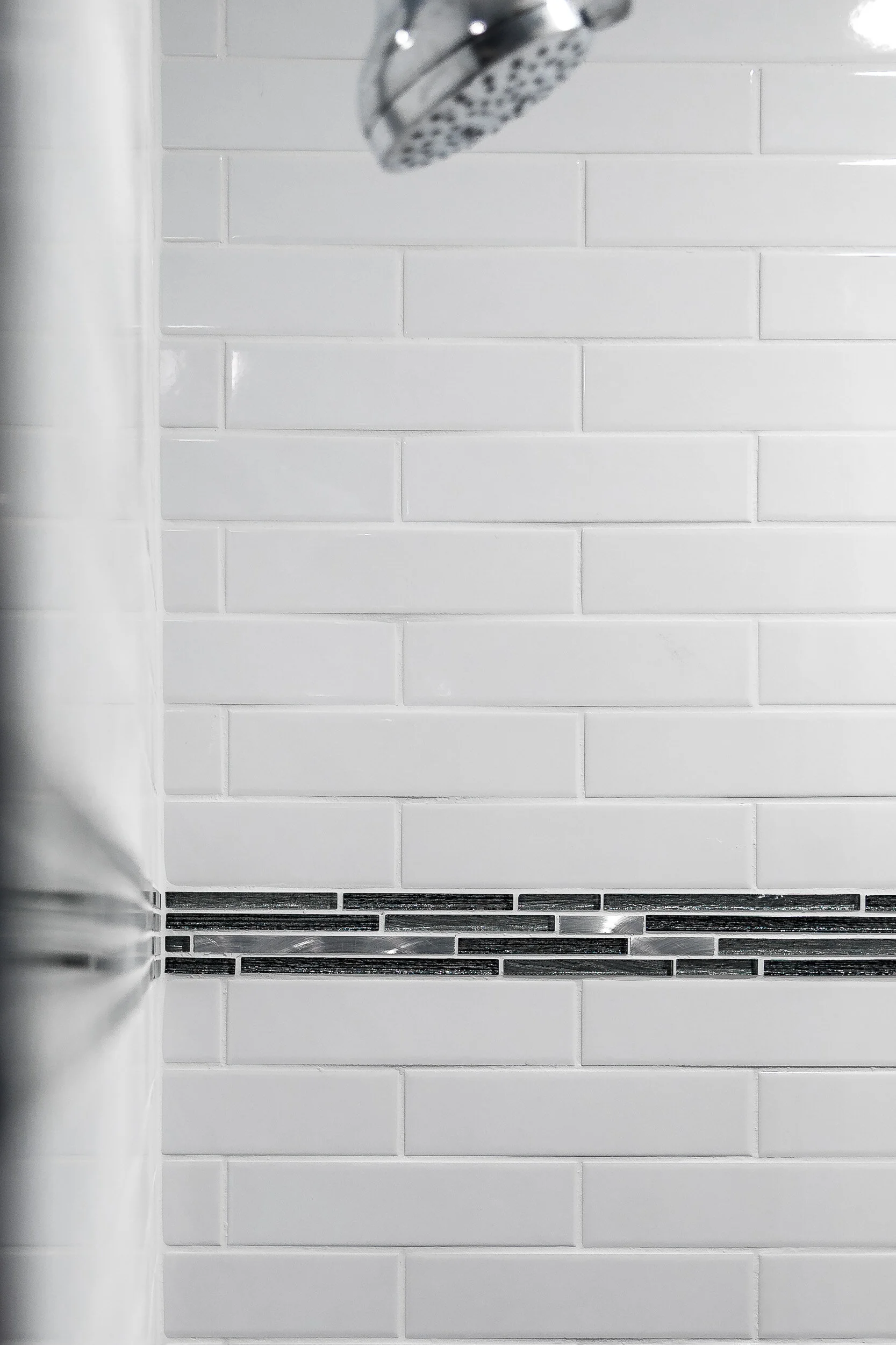 Subway-tile shower with a glass mosaic accent band
